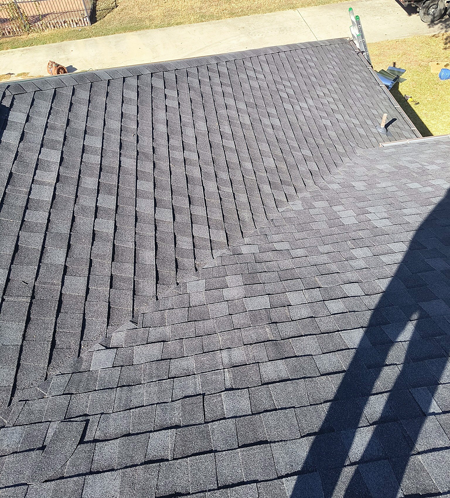 A finished shingle roof seen from above, the new courses running down to the eaves